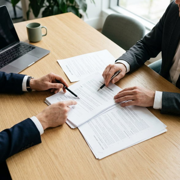 Dos personas revisando documentos laborales sobre una mesa de trabajo